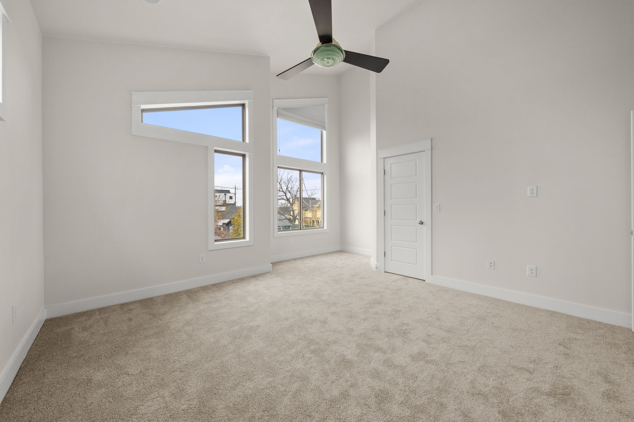 1160 Nickols Avenue, Unit A Austin, TX 78721 - Photo 22 of 40 Spare room with a towering ceiling, healthy amount of natural light, light carpet, and ceiling fan