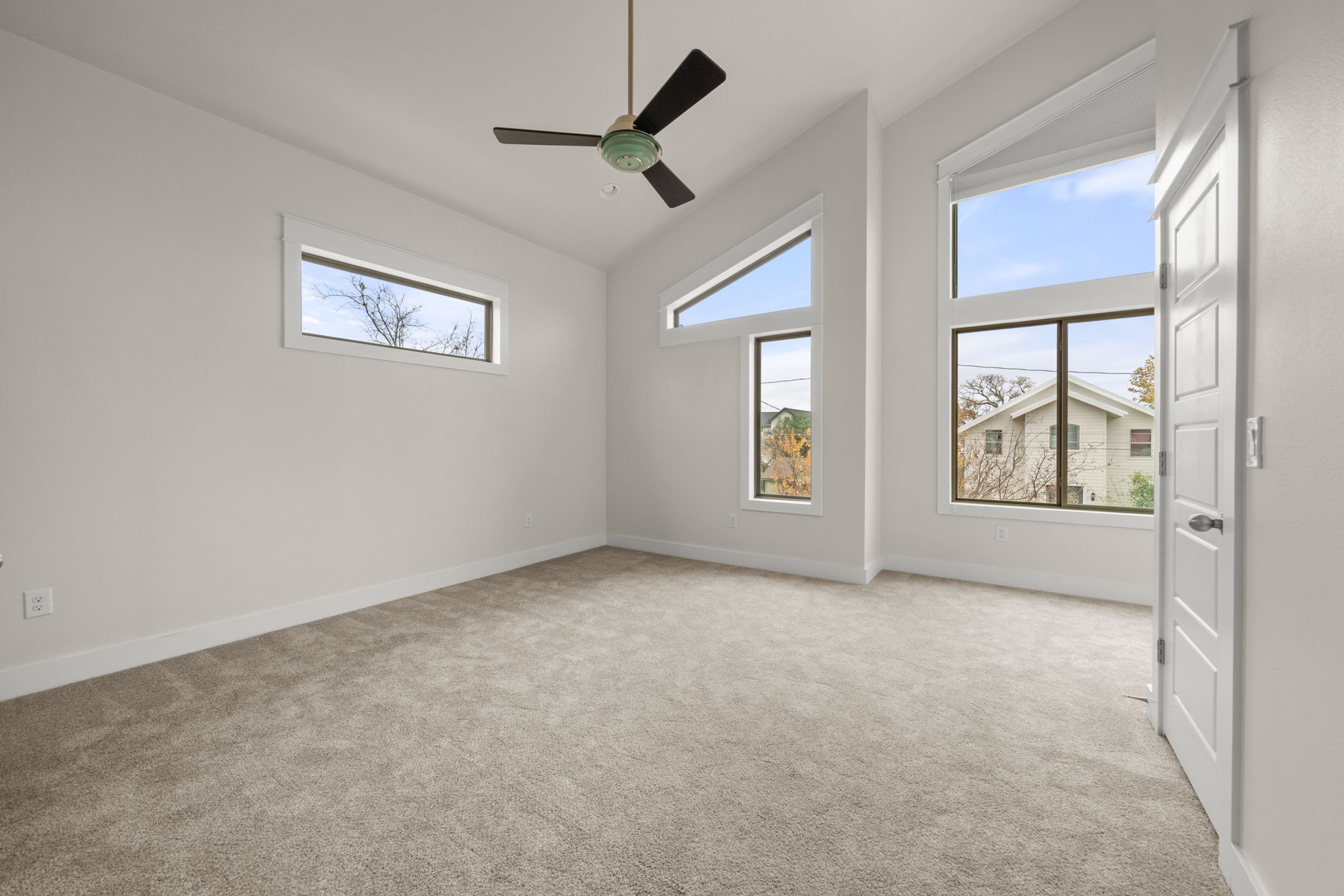 1160 Nickols Avenue, Unit A Austin, TX 78721 - Photo 23 of 40 Empty room featuring light colored carpet, a ceiling fan, plenty of natural light, and vaulted ceiling