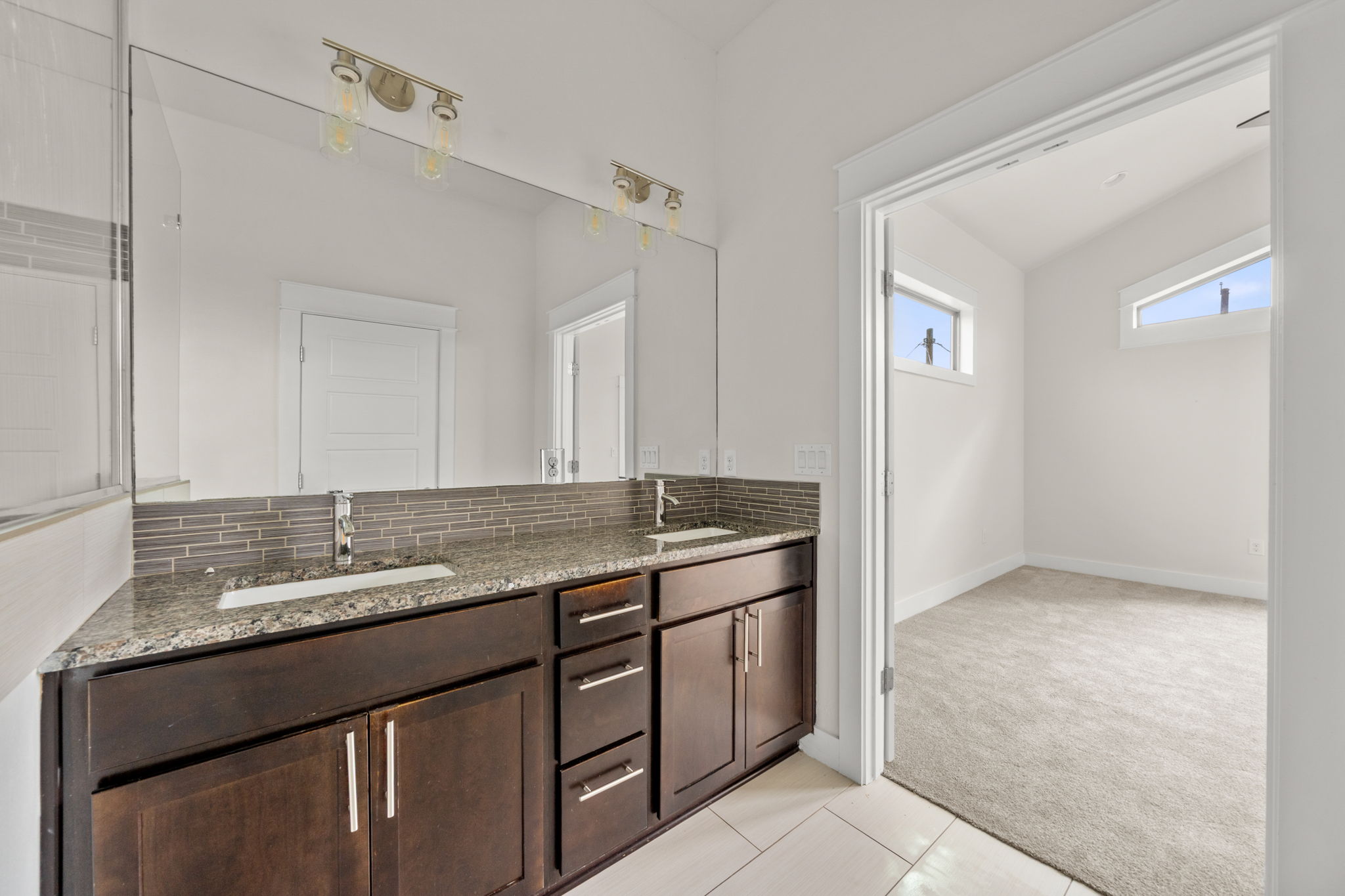 1160 Nickols Avenue, Unit A Austin, TX 78721 - Photo 27 of 40 Bathroom featuring light colored carpet, double vanity, light tile patterned floors, and decorative backsplash