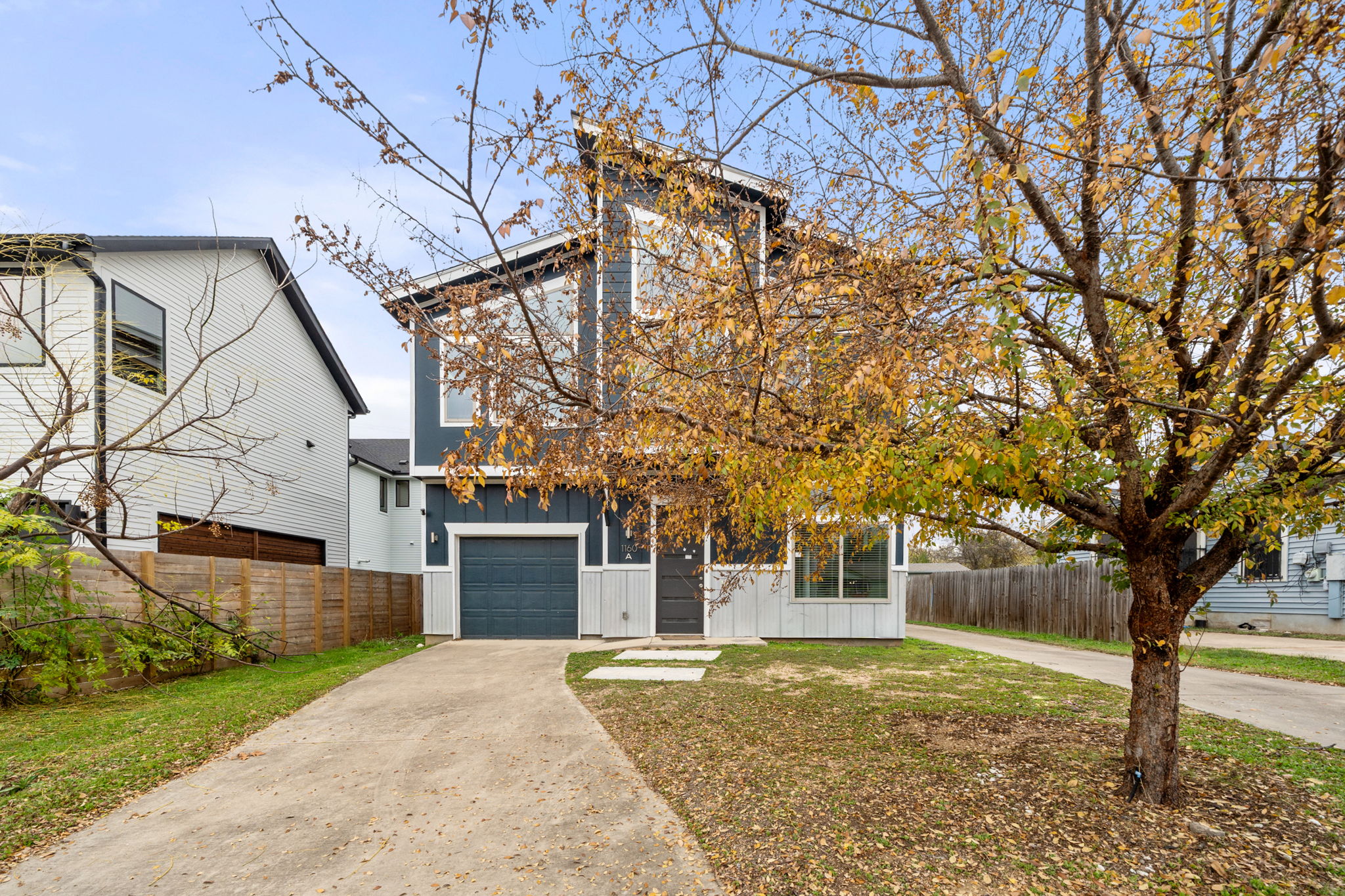 1160 Nickols Avenue, Unit A Austin, TX 78721 - Photo 36 of 40 View of front of house with board and batten siding, concrete driveway, and a garage