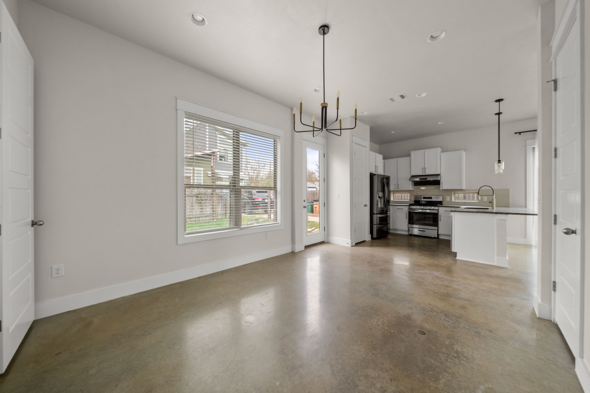 1160 Nickols Avenue, Unit A Austin, TX 78721 - Photo 38 of 40 Kitchen with recessed lighting, decorative light fixtures, stainless steel appliances, open floor plan, and white cabinets