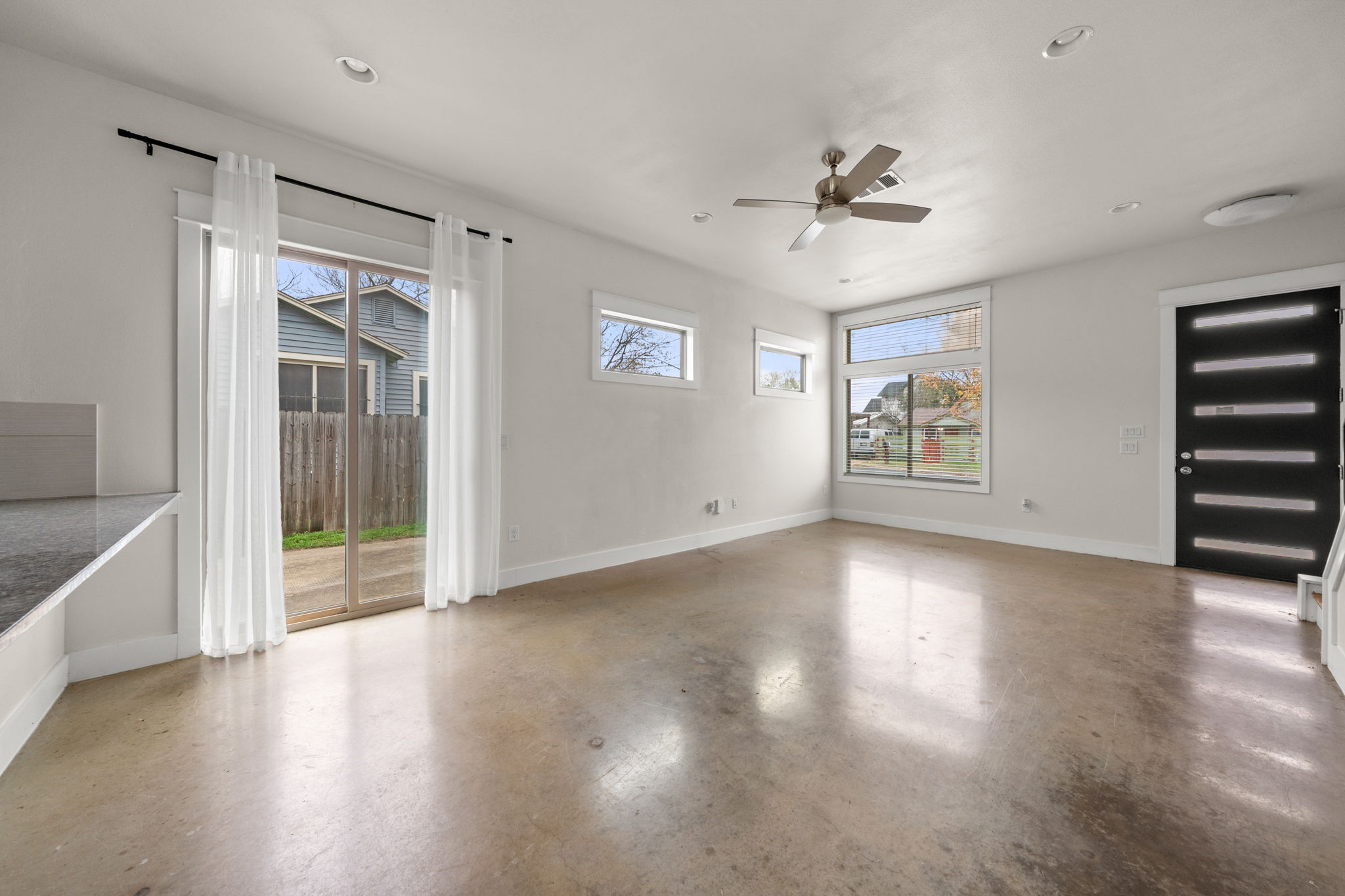 1160 Nickols Avenue, Unit A Austin, TX 78721 - Photo 5 of 40 Unfurnished room featuring healthy amount of natural light, concrete flooring, recessed lighting, and a ceiling fan