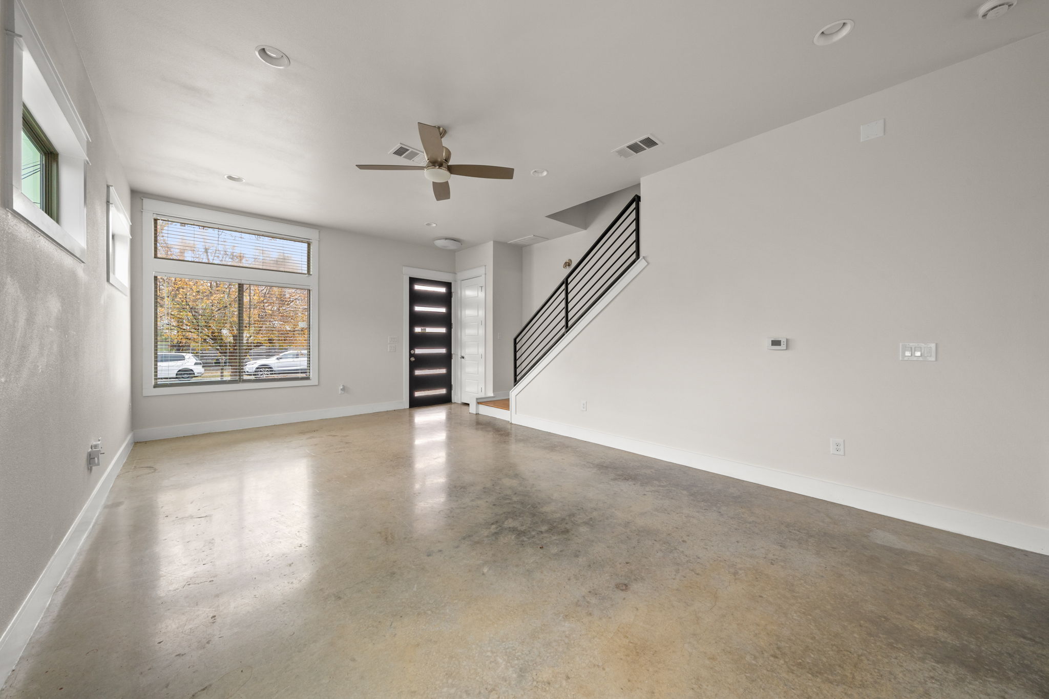 1160 Nickols Avenue, Unit A Austin, TX 78721 - Photo 6 of 40 Unfurnished living room featuring concrete flooring, ceiling fan, stairway, and recessed lighting