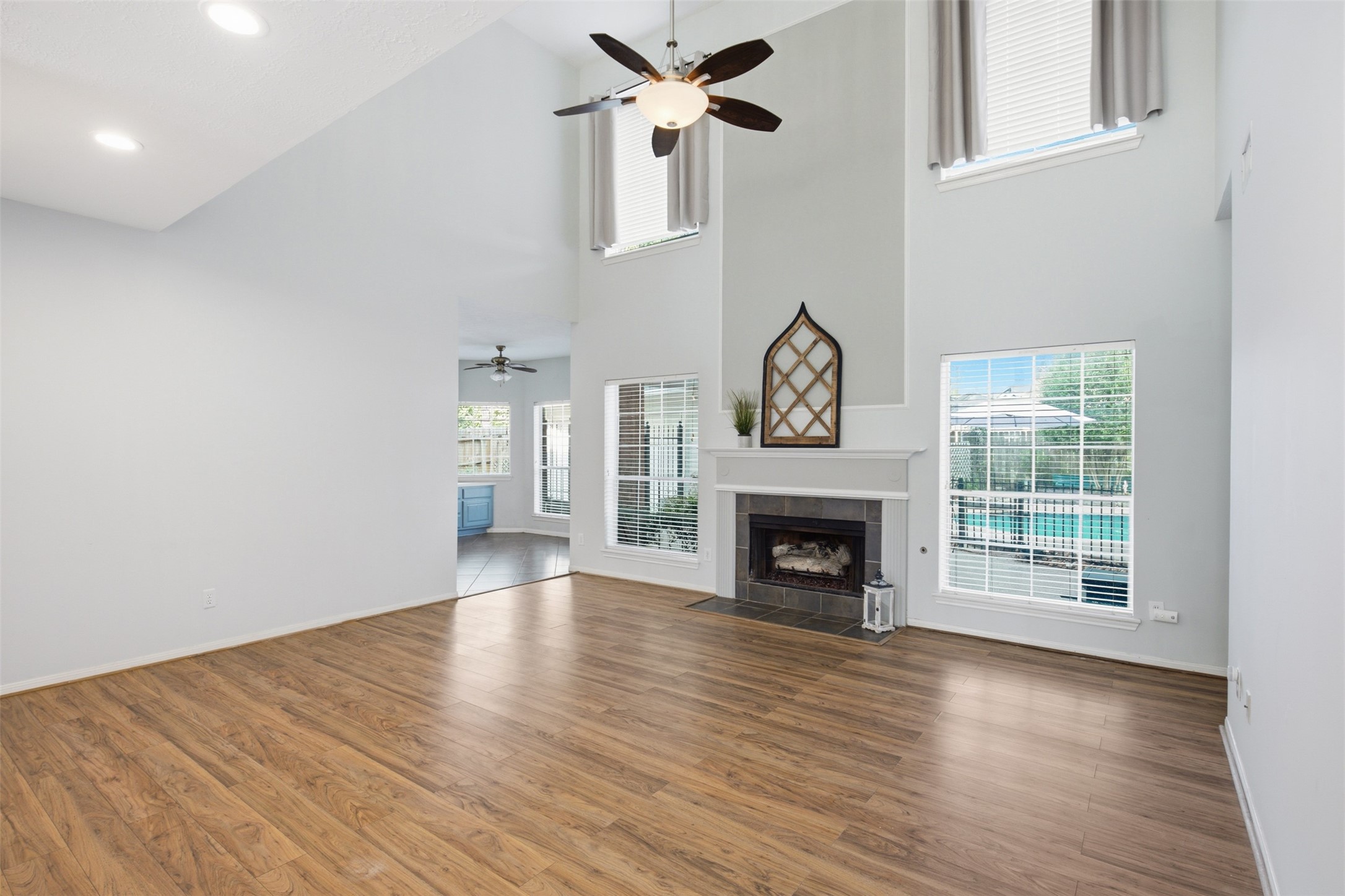 323 Magic Oaks Court Spring, TX 77388 - Photo 17 of 49 Note the large ceiling fan and the second story windows that have blinds and drapes. Accent area above the mantle is painted slightly darker to add visual interest.