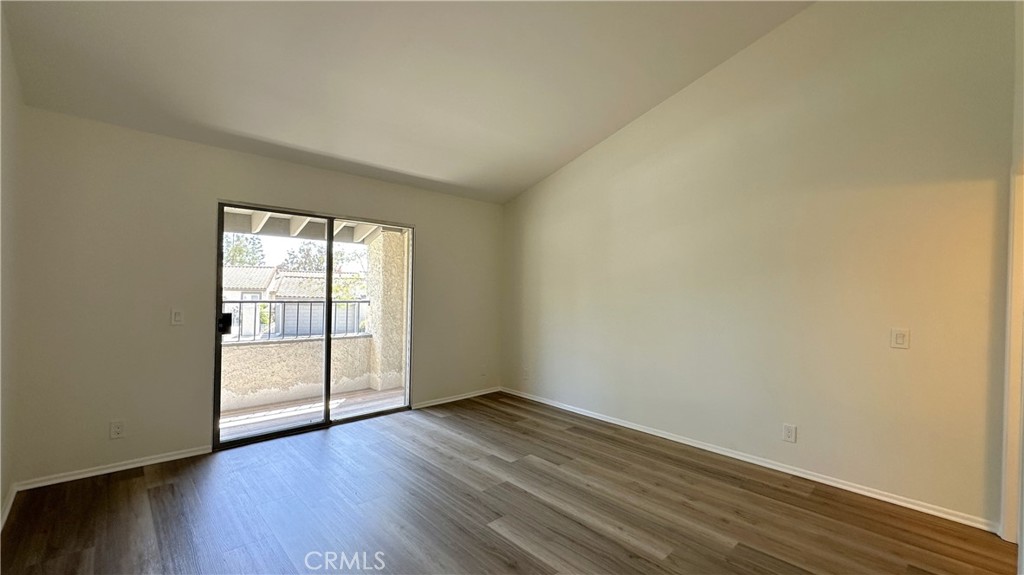 19519 Rinaldi Street, Unit 57 Porter Ranch, CA 91326 - Photo 19 of 28 an empty room with wooden floor and windows