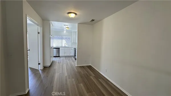a view of empty room with wooden floor