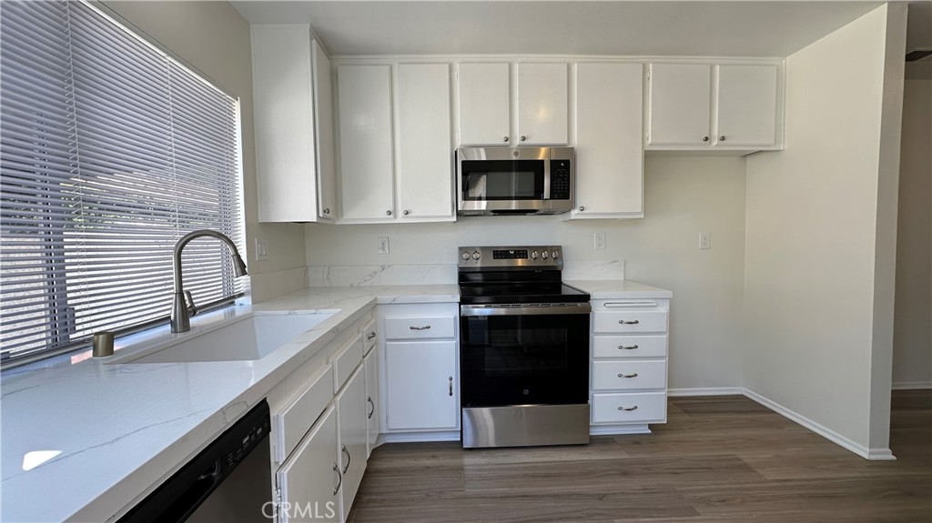 19519 Rinaldi Street, Unit 57 Porter Ranch, CA 91326 - Photo 9 of 28 a kitchen with stainless steel appliances white cabinets and a sink