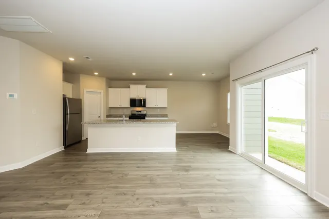a view of kitchen with stainless steel appliances kitchen island refrigerator sink and cabinets