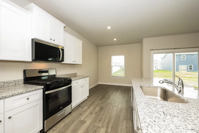 a kitchen with granite countertop a stove a sink and a granite counter tops