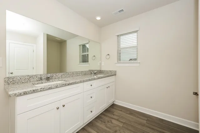 a bathroom with a granite countertop sink and mirror