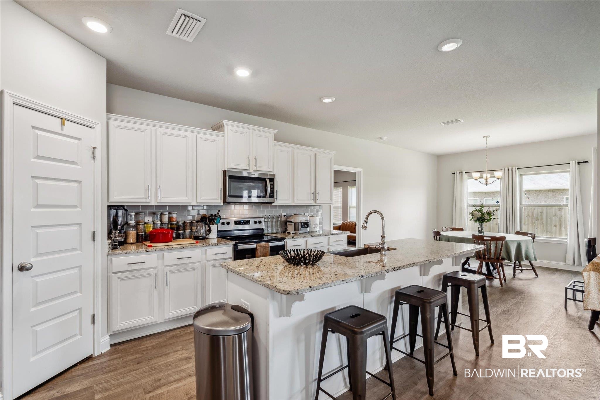 10501 Loamy Avenue Mobile, AL 36695 - Photo 10 of 30 Kitchen featuring white cabinetry, stainless steel appliances, decorative backsplash, sink, and a kitchen island with sink
