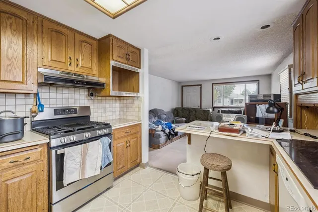 a kitchen with a stove a sink dishwasher and cabinets with wooden floor