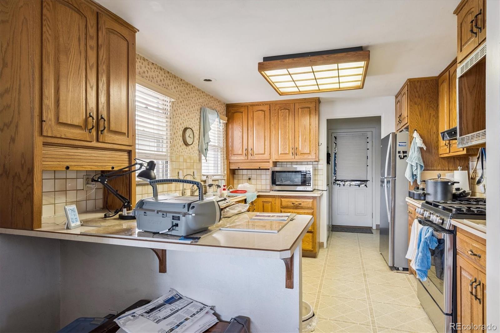 5465 Reed Court Arvada, CO 80002 - Photo 9 of 27 a kitchen with stainless steel appliances a sink and a refrigerator