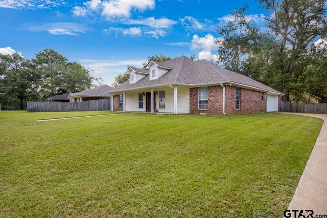 a view of a house with a yard and sitting area