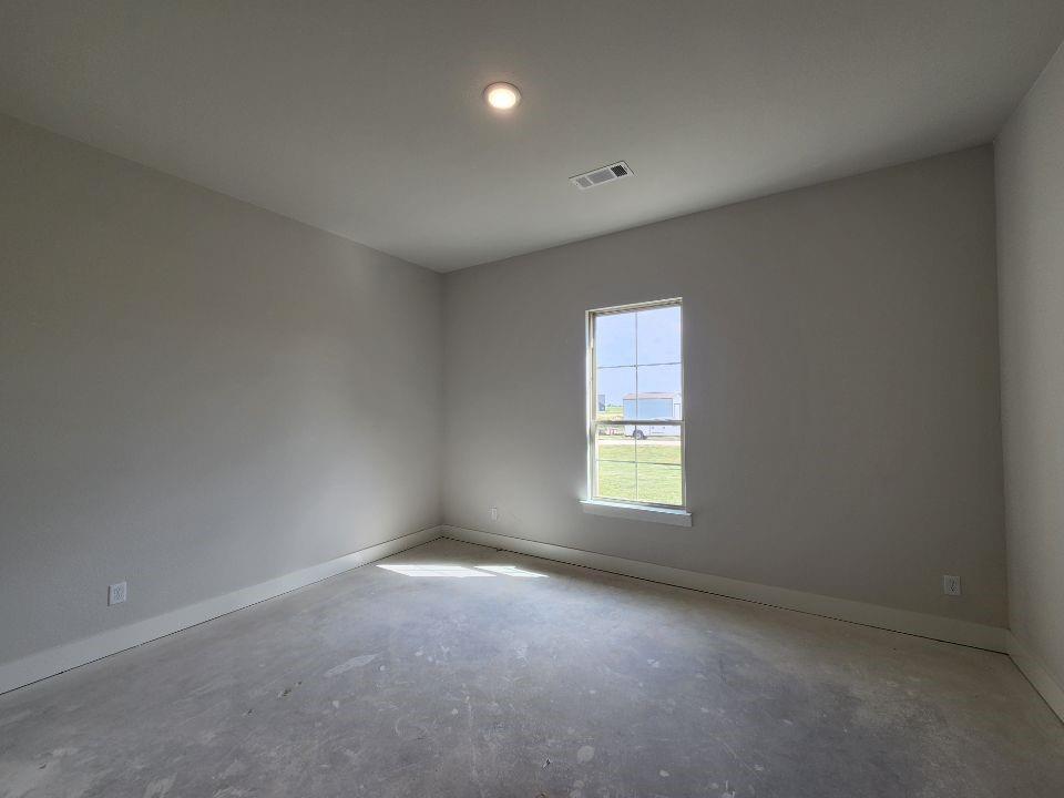 2305 Gypsum Street Krum, TX 76249 - Photo 7 of 22 Single window with grid inserts, light gray wall paint, white trim, recessed ceiling lighting, and exposed concrete flooring