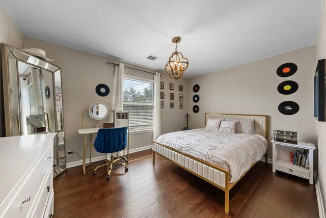 a bedroom with a bed and a desk next to a window