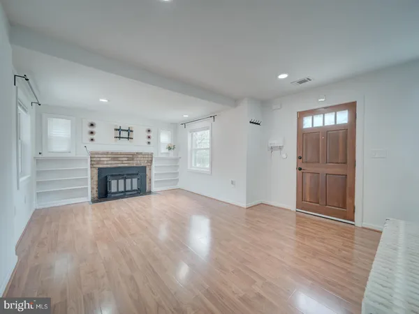 a view of empty room with wooden floor and fireplace