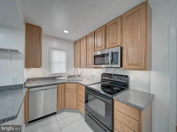 a kitchen with granite countertop a sink stove and microwave