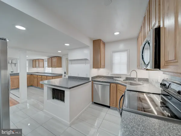 a kitchen with granite countertop a sink and white cabinets