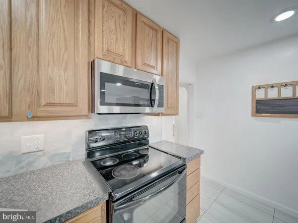 a kitchen with granite countertop a stove and a microwave