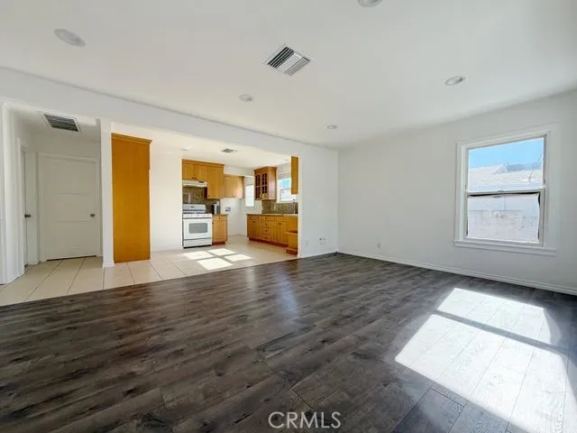 a view of empty room with wooden floor and window