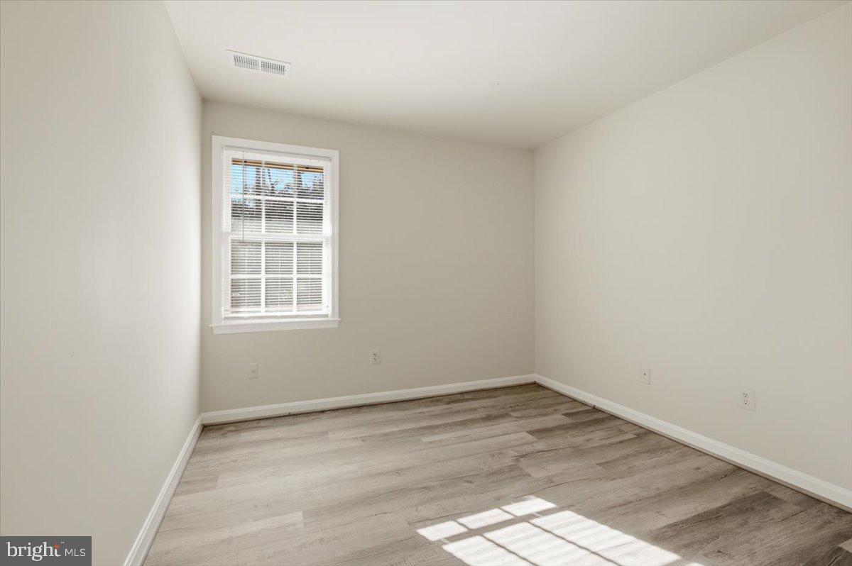 Margate Court, Unit A Sterling, VA 20164 - Photo 14 of 20 an empty room with wooden floor and windows