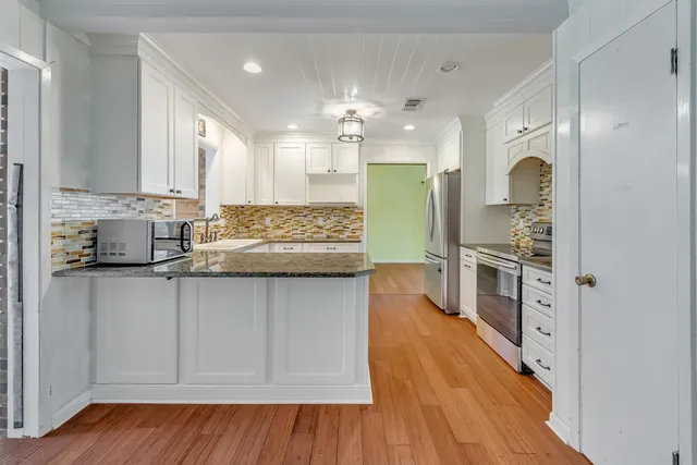 a view of a backyard with plants and large trees