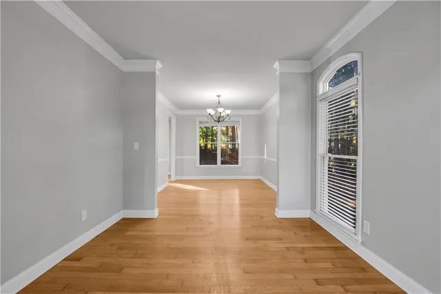 a view of an empty room with window and stairs
