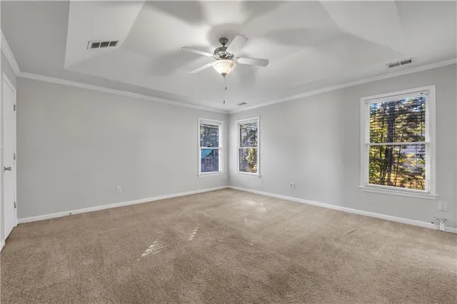 an empty room with windows and ceiling fan