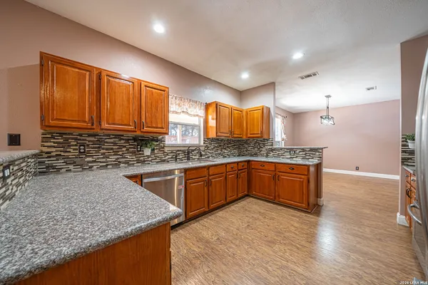 a kitchen with granite countertop wooden cabinets and a sink