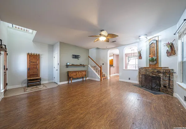 a view of a livingroom with wooden floor and a ceiling fan