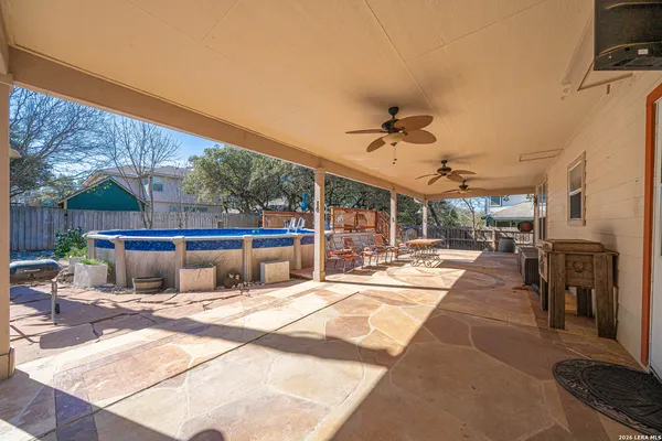 a view of a patio with a dining table and chairs with a barbeque grill