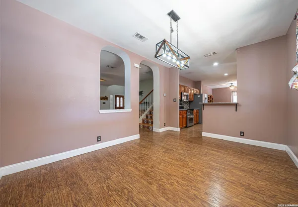 a view of a kitchen with a refrigerator and a wooden floor