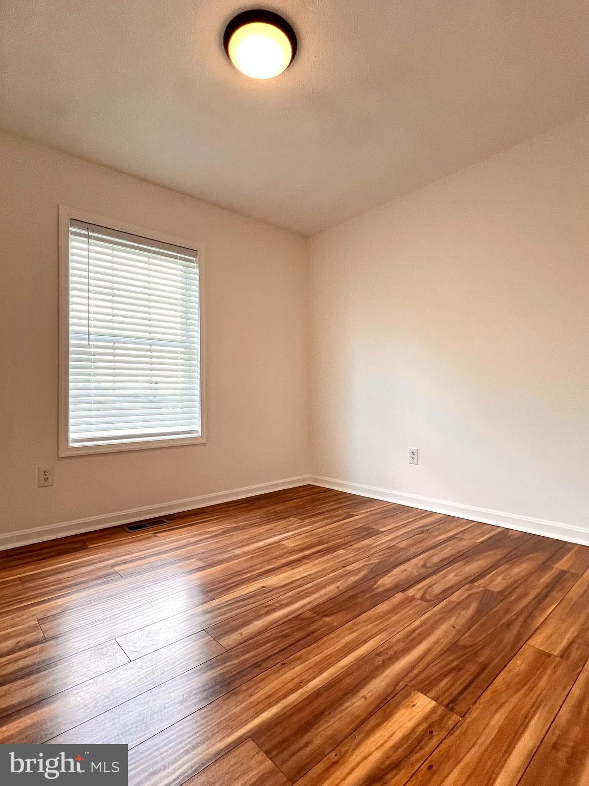 179 Robelei Drive Ranson, WV 25438 - Photo 12 of 17 an empty room with wooden floor and windows