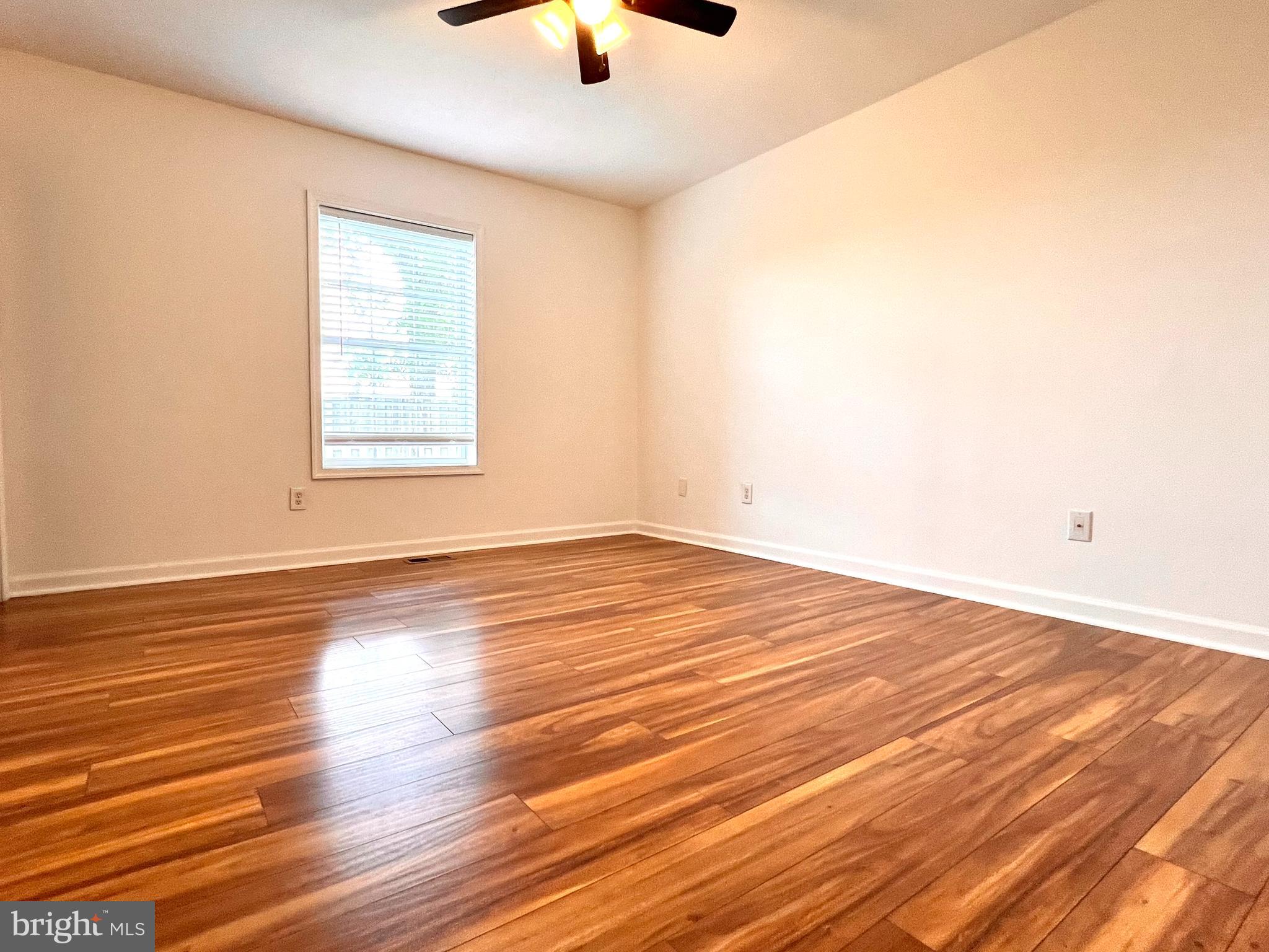 179 Robelei Drive Ranson, WV 25438 - Photo 9 of 17 an empty room with wooden floor and windows
