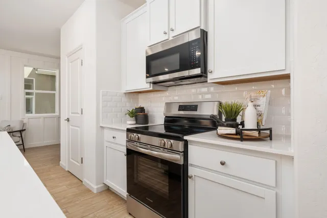 a kitchen with stainless steel appliances a stove a microwave oven cabinets and a counter space