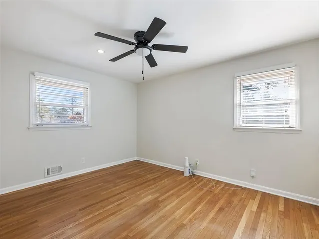a view of a big room with wooden floor and windows