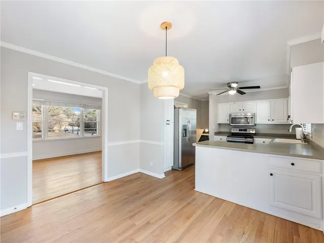 a kitchen with granite countertop a refrigerator a stove a microwave and wooden floor