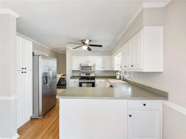 a kitchen with stainless steel appliances granite countertop a refrigerator a stove and a sink