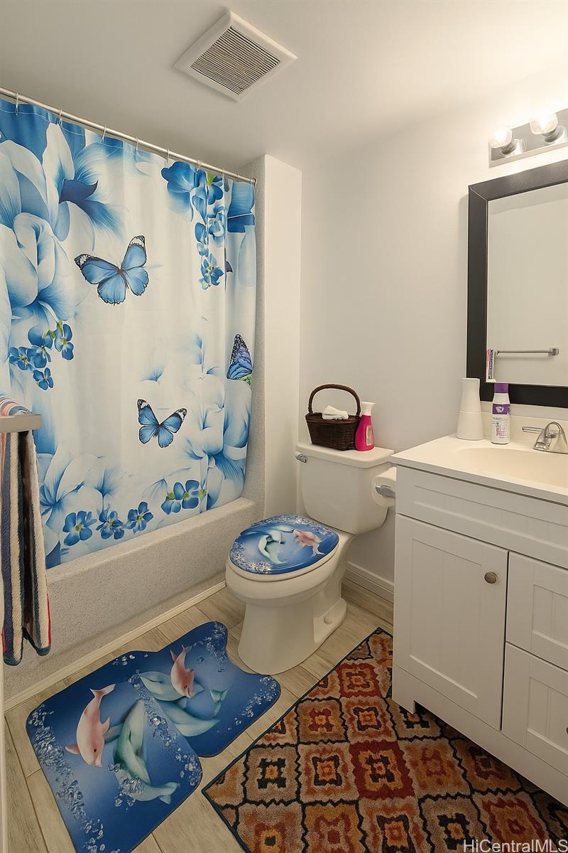 1400 Pensacola Street, Unit 903 Honolulu, HI 96822 - Photo 6 of 14 a bathroom with a sink a toilet and a mirror