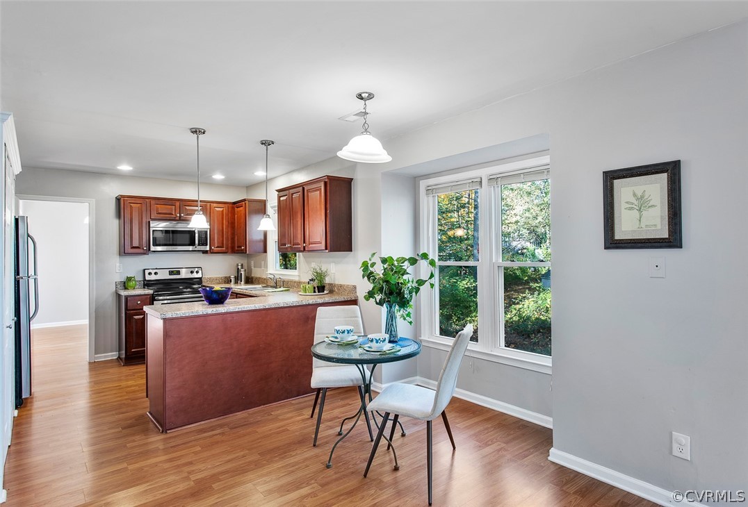 4501 Rabbit Foot Lane North Chesterfield, VA 23236 - Photo 6 of 32 a kitchen with stainless steel appliances granite countertop a stove top oven a refrigerator a dining table and chairs with wooden floor