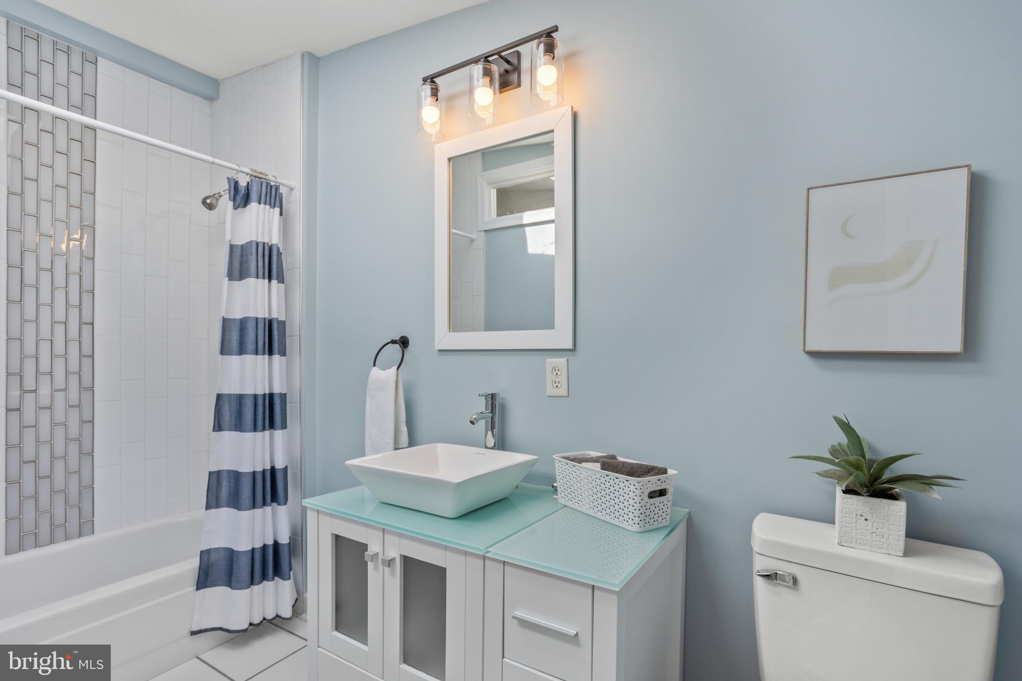 1432 Andre Street Baltimore, MD 21230 - Photo 14 of 25 a bathroom with a granite countertop sink toilet a mirror and shower