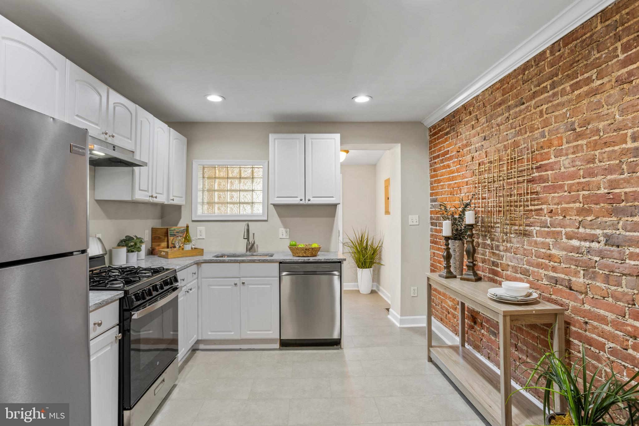 1432 Andre Street Baltimore, MD 21230 - Photo 7 of 25 a kitchen with stainless steel appliances a stove a sink a refrigerator a stove a cabinets and a refrigerator