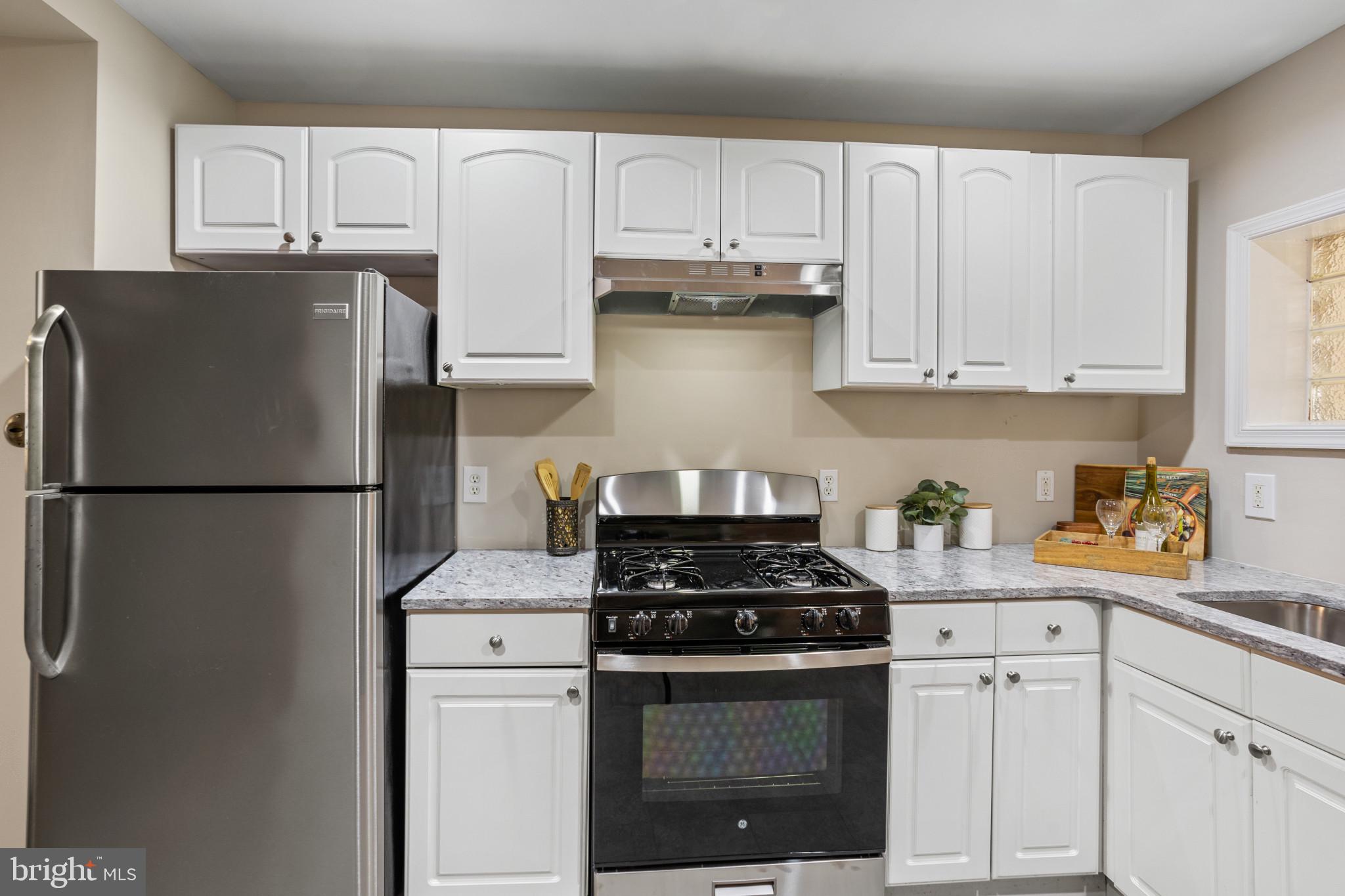 1432 Andre Street Baltimore, MD 21230 - Photo 8 of 25 a kitchen with stainless steel appliances granite countertop a refrigerator sink stove and white cabinets