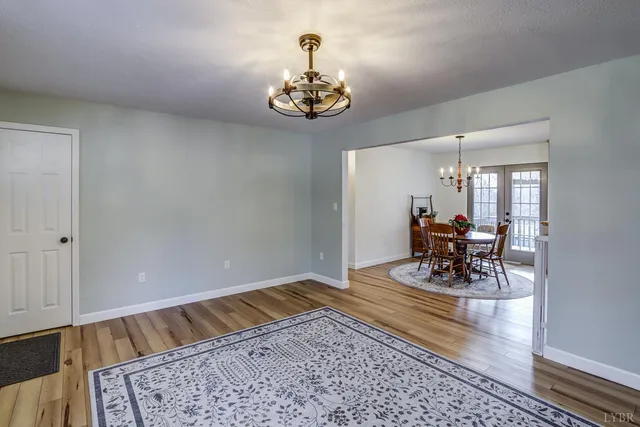 a spacious bedroom with a bed and a flat tv screen on dresser