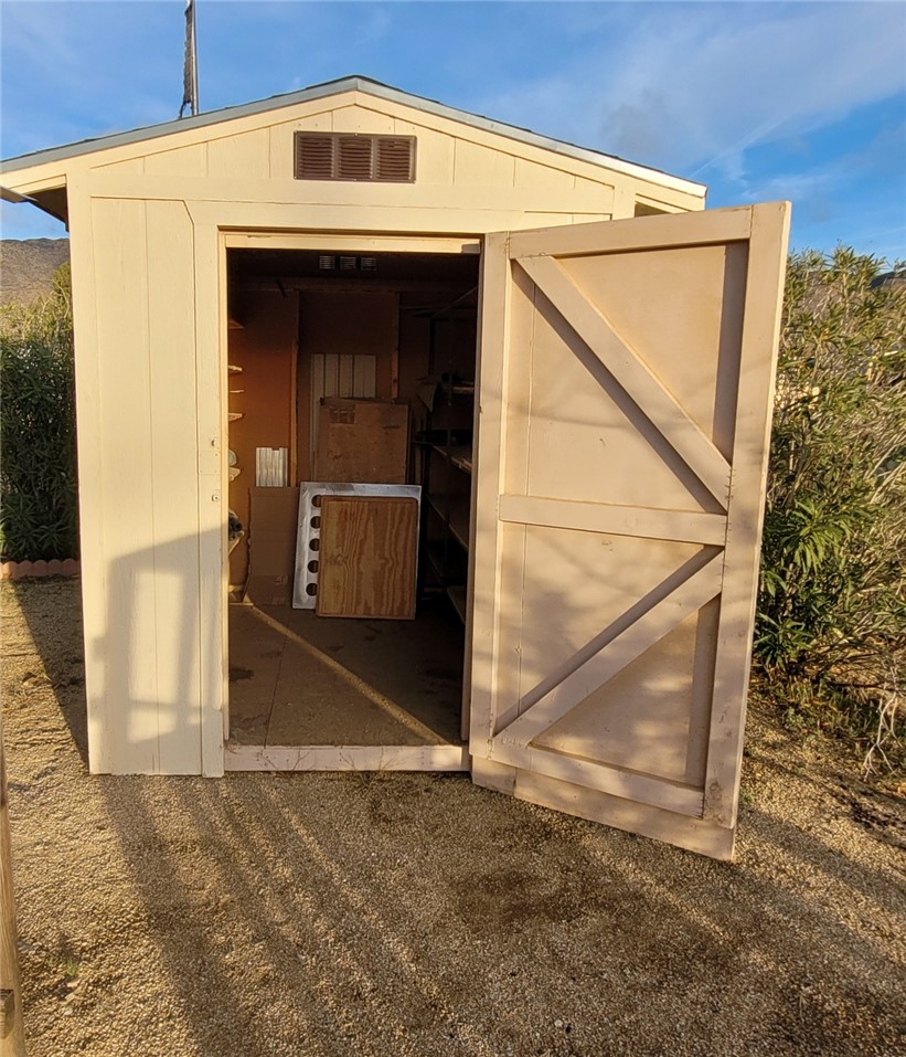 9732 2nd Street Chloride, AZ 86431 - Photo 8 of 28 This property features a detached storage shed with a gabled roof and a light-colored exterior