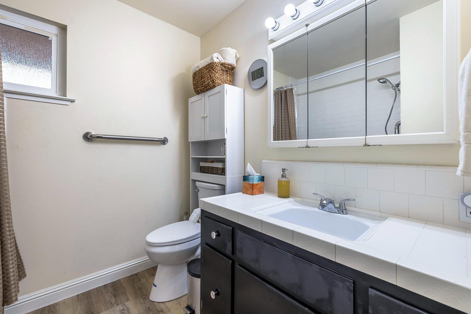 2877 Caesar Avenue Clovis, CA 93612 - Photo 19 of 32 a bathroom with a sink a toilet and a mirror