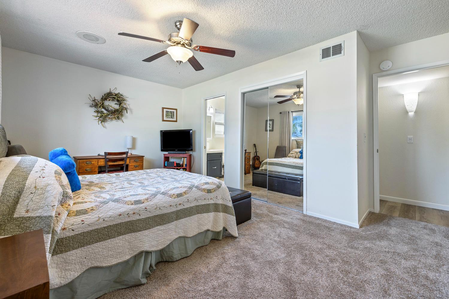 2877 Caesar Avenue Clovis, CA 93612 - Photo 23 of 32 a bedroom with a bed and a chandelier