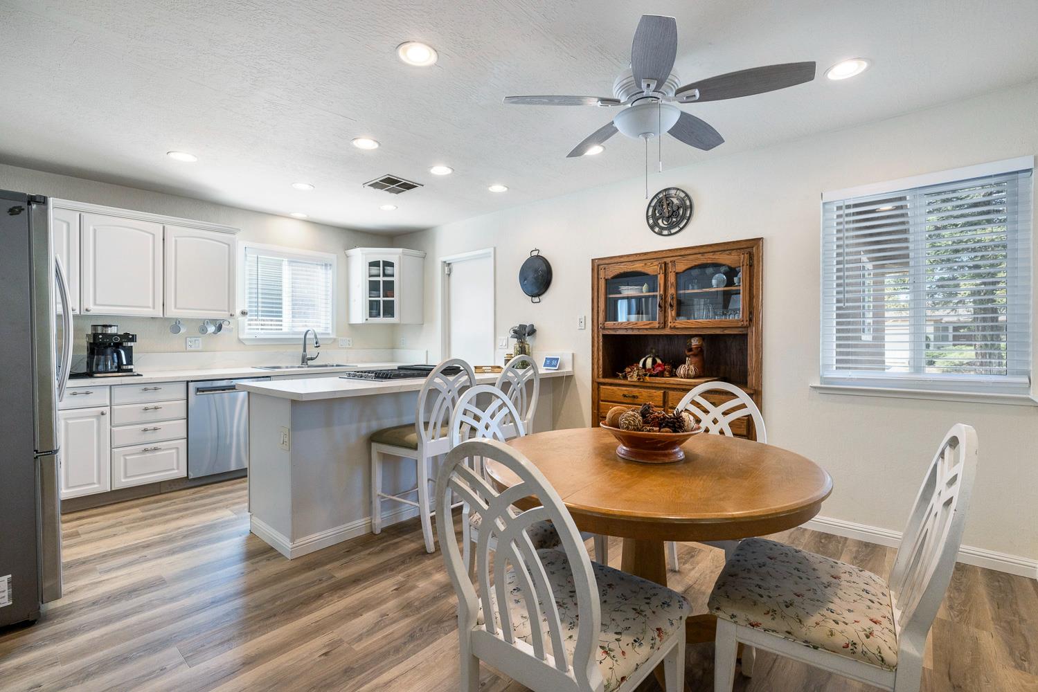 2877 Caesar Avenue Clovis, CA 93612 - Photo 10 of 32 a kitchen with a dining table chairs stainless steel appliances and cabinets