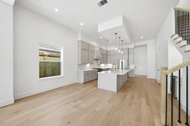 a large kitchen with a large window and stainless steel appliances